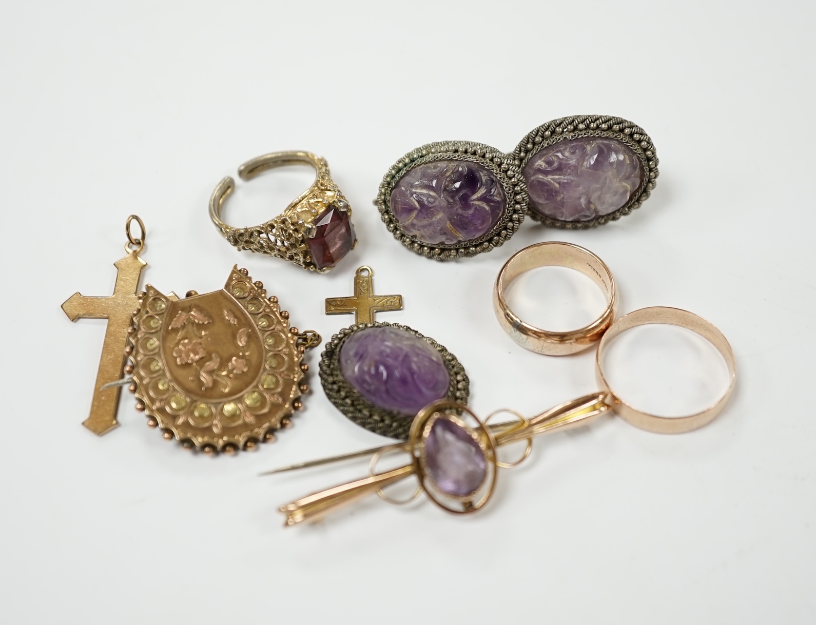 A George V 9ct gold band, a late Victorian 9ct gold horseshoe shaped brooch and a 9ct and amethyst set bar brooch, gross weight 7.7 grams, together with two rings and two cross pendants and an amethyst quartz set suite o